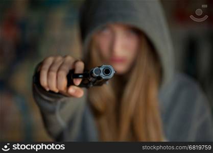 Teenager Girl Aiming a gun at the camera,, blurred focus