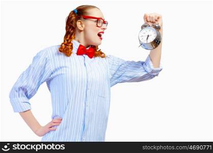 Teenager girl holding alarm clock. Teenager girl in red glasses holding alarm clock