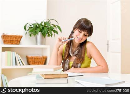 Teenager girl home - student write homework sitting at table