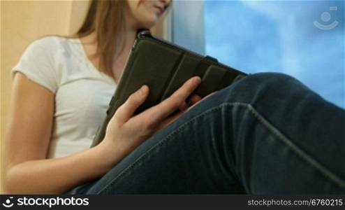 Teenager Girl Listening Music On Digital Tablet, Looking Through The Window