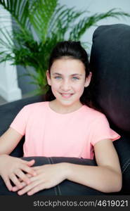 Teenager girl resting on the sofa with a beautiful plant of background