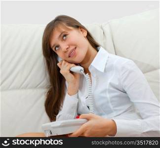 teenager girl sitting on the couch and talking on the phone