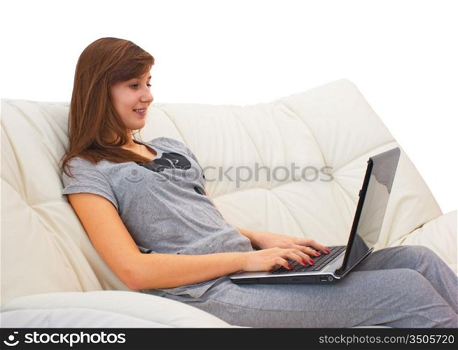teenager girl sitting on the couch with a laptop and yawns isolated