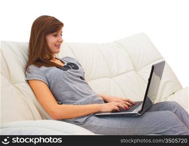 teenager girl sitting on the couch with a laptop and yawns isolated