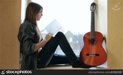 Teenager Girl Studying Guitar Chart At Home