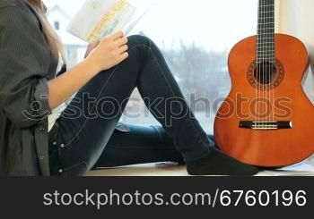 Teenager Girl Studying Guitar Fingerings At Home