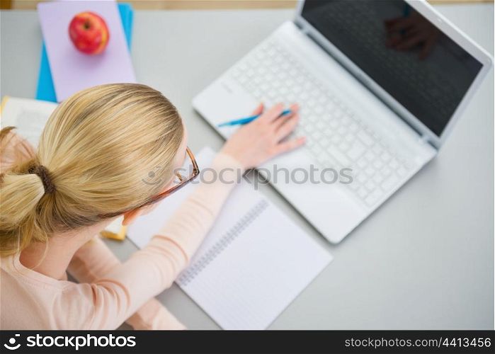 Teenager girl studying in the kitchen