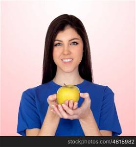Teenager girl with a yellow apple isolated on pink background