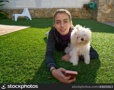 Teenager girl with mobile phone and doggy pet lying on grass backyard