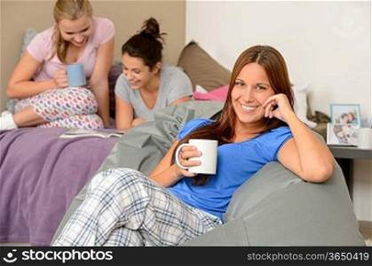 Teenager girls reading and drinking at slumber party