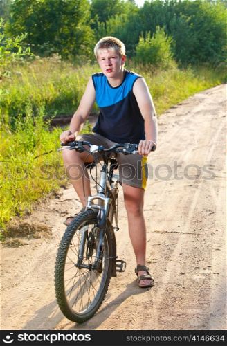 Teenager goes on bicycle on country road