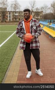 teenager holding basketball ball outdoors