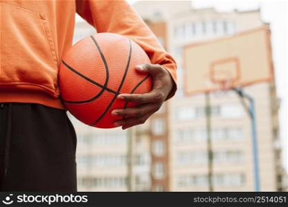 teenager holding basketball outdoors