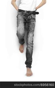 Teenager in black jeans and a white t-shirt barefoot isolated. With clipping path. Teenager in black jeans and a white t-shirt, barefoot, isolated.. Teenager in black jeans and a white t-shirt, barefoot, isolated.