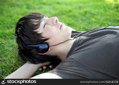 Teenager lying on grass listening to music