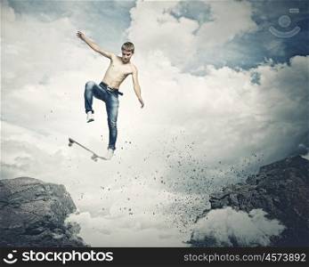 Teenager on skateboard. Skater in jeans jumping over mountain gap