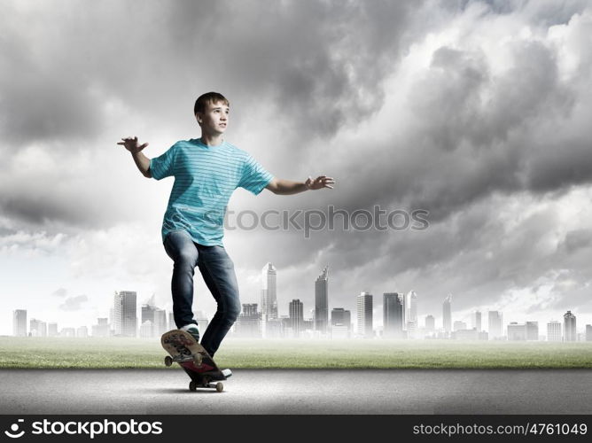 Teenager on skateboard. Skater in jeans riding on road against city background