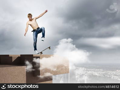 Teenager on skateboard. Skater in jeans riding on top of building