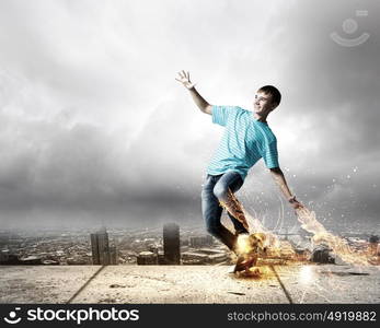 Teenager on skateboard. Skater in jeans riding on top of building