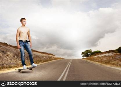 Teenager on skateboard. Young skater in jeans riding on road