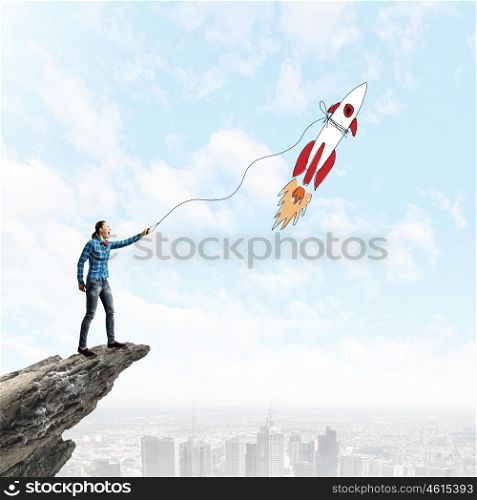 Teenager on top. Young woman catching rocket flying in sky with rope
