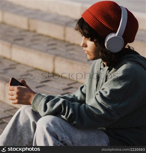 teenager outdoors using smartphone listening music headphones