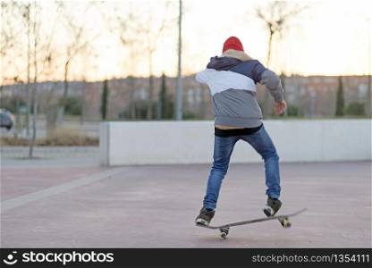 teenager practicing with skateboard at sunrise city