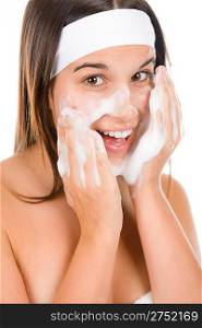 Teenager problem skin care - woman wash face with cleansing foam