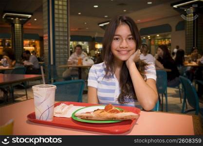 Teenager sitting in mall food court