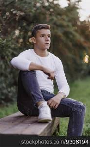 Teenager sitting on a park bench, looking away.