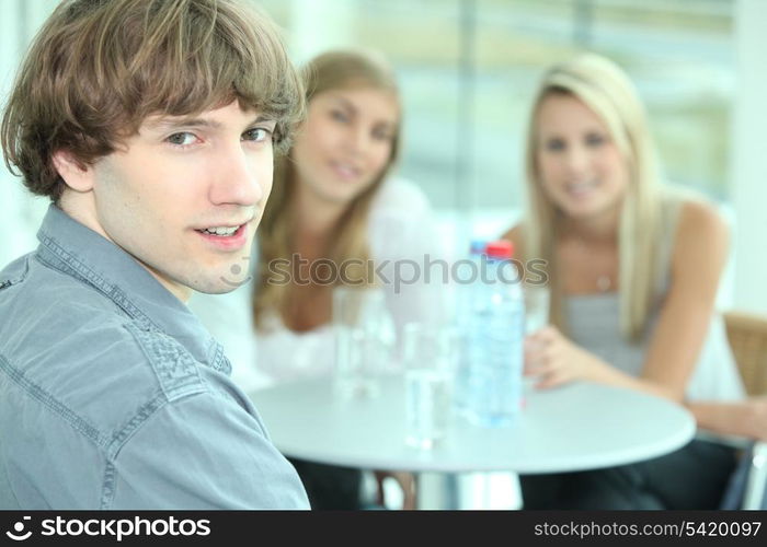 Teenager sitting with his female friends