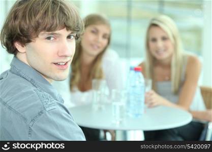 Teenager sitting with his female friends