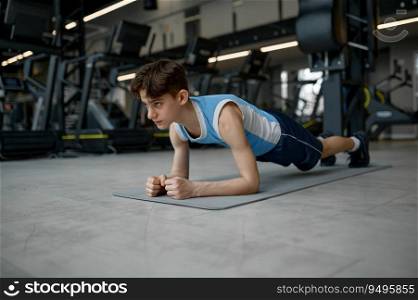 Teenager sport boy standing in plank doing training exercise for muscle strength. Children workout at gym. Teenager sport boy standing in plank doing training exercise for muscle strength