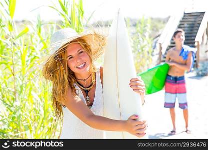 Teenager surfers walking to the beach in sunny summer day