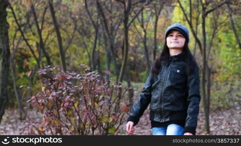 Teenager walking through the woods in autumn season