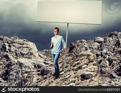 Teenager with banner. Young man in glasses holding blank banner. Place for text