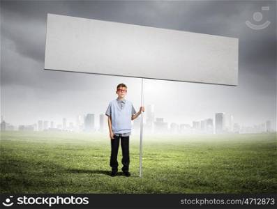 Teenager with banner. Young man on road holding blank banner. Place for text