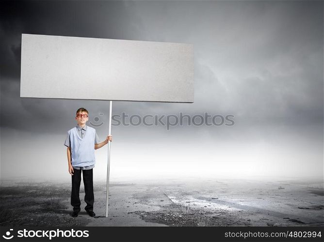 Teenager with banner. Young man on road holding blank banner. Place for text