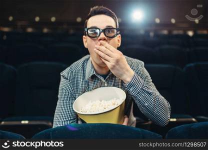 Teenager with popcorn fascinated watching the film in cinema. Showtime, entertainment industry
