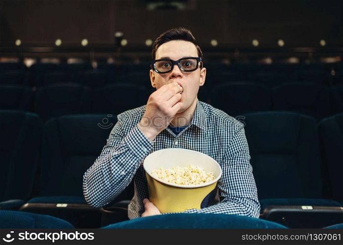 Teenager with popcorn fascinated watching the film in cinema. Showtime, entertainment industry. Teenager fascinated watching the film in cinema