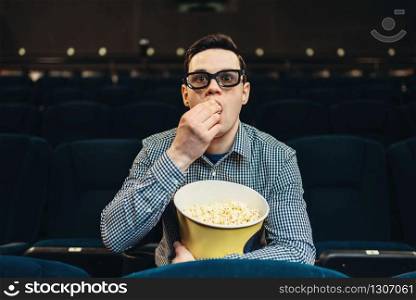 Teenager with popcorn fascinated watching the film in cinema. Showtime, entertainment industry. Teenager fascinated watching the film in cinema