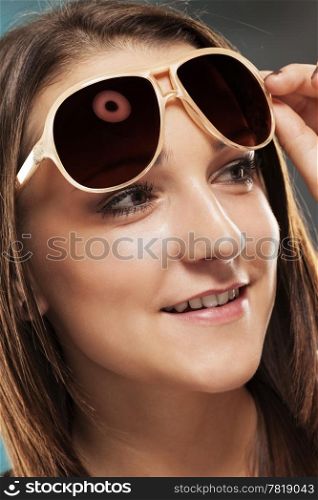 teenager with sunglasses. teenager lifting her sunglasses looking to side