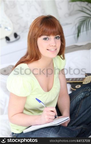 Teenager writing in notebook
