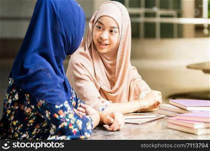 Teenager Young Adult Asian Thai Muslim university college student reading book together using for education concept