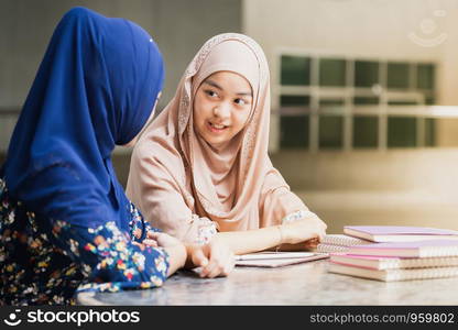 Teenager Young Adult Asian Thai Muslim university college student reading book together using for education concept