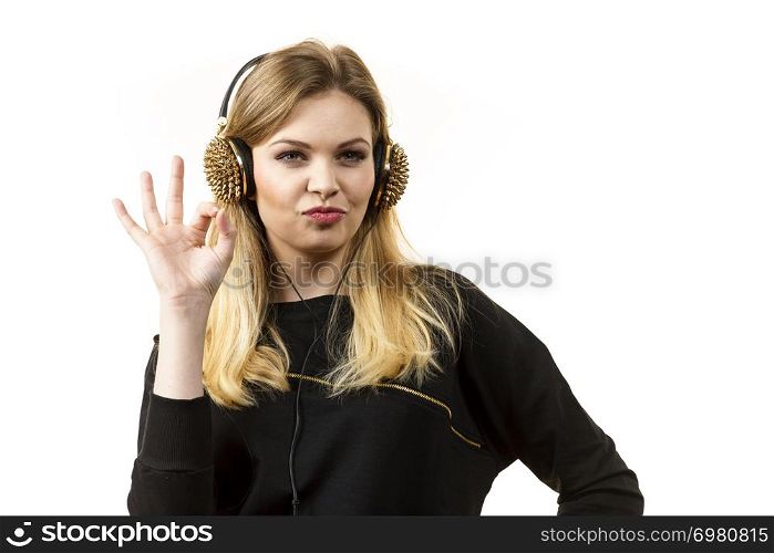 Teenager young grunge woman listening to music on headphones with spikes. Female enjoying her passion.. Teenage woman wearing headphones