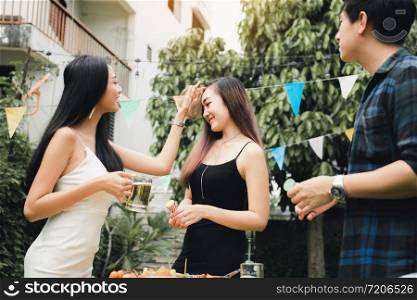 Teenagers are enjoying a garden party at home and holding the beer glass in hand.