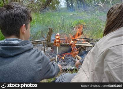 Teenagers enjoying together barbecue outdoors