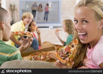 Teenagers Hanging Out In Front Of Television Eating Pizza