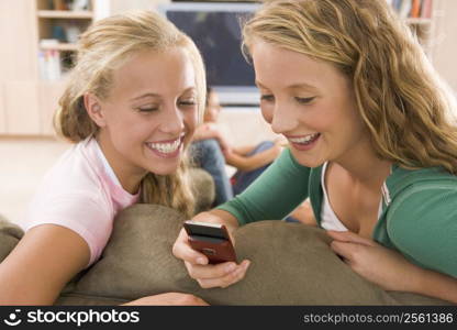 Teenagers Hanging Out In Front Of Television Using Mobile Phones